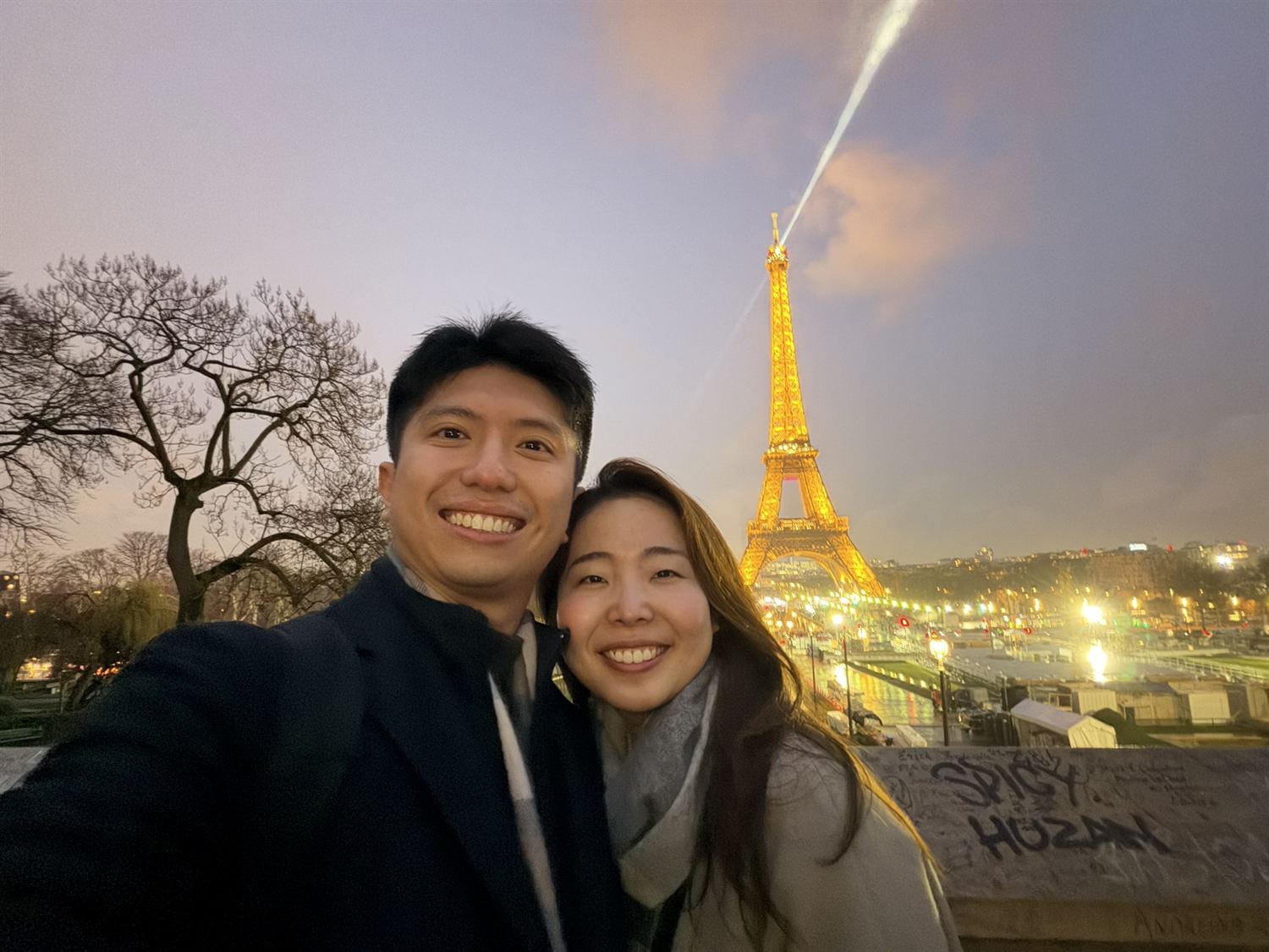 Shawn and Hitomi smiling in front of the Eiffel Tower